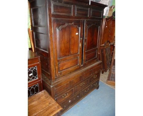 A peg-joyned Georgian Oak Cupboard on Chest, the upper opposing doors with shaped raised and fielded panels opening to reveal