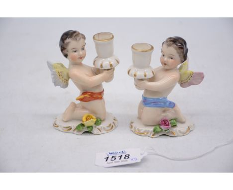 A pair of Dresden candle holders in the form of kneeling cherubs, 3 1/2" tall (one repaired).
