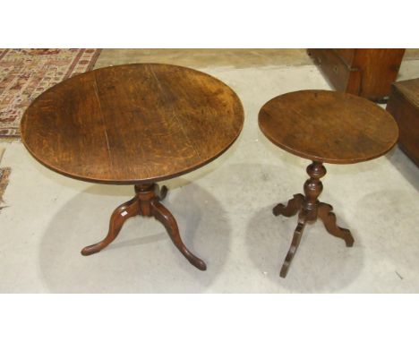 An antique oak country circular tripod table on turned column and shaped legs, 53cm diameter and a larger tilt-top tripod tab