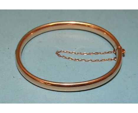 A 15ct gold hinged bangle of plain form, interior measurements 5.7 x 5cm, 11.8g. 