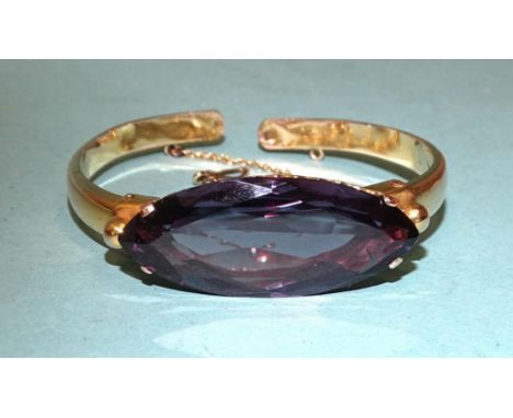 A hinged gold bangle set large marquise-cut synthetic sapphire, 38 x 16mm, bearing Middle Eastern gold marks, 21.1g. 
