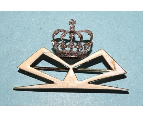 An unusual presentation brooch in the form of the monogram of Queen Marie of Romania (1875-1938), c1900, white enamel on gold
