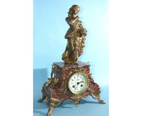 A late-Victorian marble and metal-mounted mantel clock surmounted by a robed female figure and having a painted circular enam