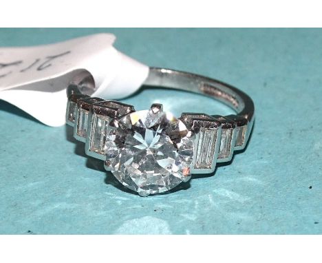 An Art Deco diamond ring claw-set a brilliant-cut diamond of approximately 2.02cts, between shoulders each set three graduate