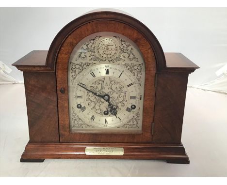 A mahogany cased mantel clock with domed top, silvered dial and chapter ring with black Roman numerals, 'Tempus Fugit' to the
