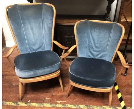 Two Ercol blonde beech and elm Windsor armchairs, each with stick-backs, blue fabric upholstered cushions and raised on turne