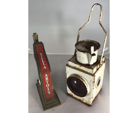 A British Rail railways lamp with red lens and swing handle, together with a vintage brass Stella Artois beer pump / tap (2) 