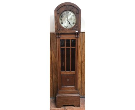 A 1930s oak long case clock, with silvered dial and Arabic numerals, spring driven movement, domed hood with carved lower spa