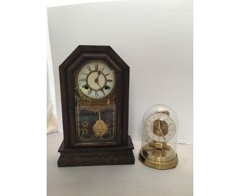 A German anniversary clock by Kundo (pendulum needs re-attaching), glass dome, white chapter ring with gold Arabic numerals, 