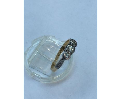 A lady's 18ct gold and platinum three stone diamond ring. All three diamonds are in an illusion setting. Estimated total diam