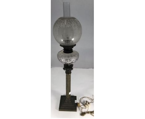 An Edwardian oil lamp with etched glass globe with fleur-de-lis and tulip design, cut glass reservoir, raised on Bronzed Cori