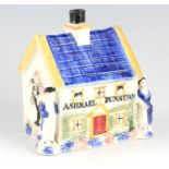 A 19TH CENTURY PRATTWARE POTTERY MONEY BOX with pearlised glaze formed as a house with male and