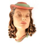 AN ART DECO STYLE POTTERY WALL MASK of a stylised young lady wearing a hat 33cm high