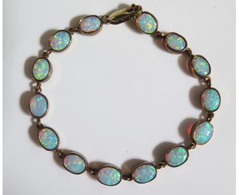 A 9ct Yellow Gold and White Opal Mounted Bracelet set with fourteen 8x6mm stones, 19cm, 12.2g 