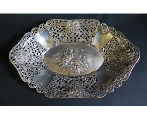 A German .800 Silver Bread Basket with repoussé decoration of a recumbent lady playing harp and surrounded by putto and with 