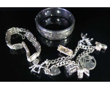 A Silver Charm Bracelet including risque lady in bath, gate-link bracelet and hinged bangle, 38g 