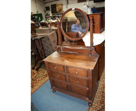 A 1940's Oak Dressing Chest with circular bevel plate mirror in finial top supports with inner shaped moulded edge shelf on c