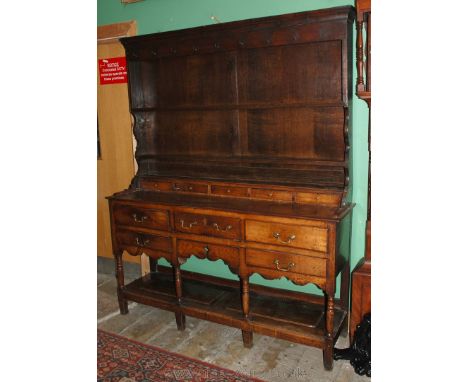 An early 19th c. Oak Potboard Dresser with plate rack having moulded cornice over plain frieze with cup hooks over rectangula