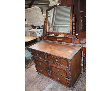 A 1940's Oak Jacobean style Dressing Chest with arch top bevel plate mirror in bobbin style turned supports and having moulde