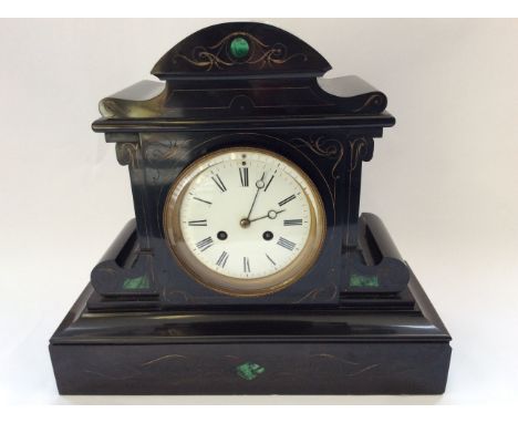 A black slate mantel clock with green marble inlay and engraved design.