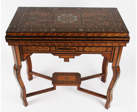 A Moroccan fold over games table with extensively inlaid body and interior, the hinged lid revealing similar inlaid interior 