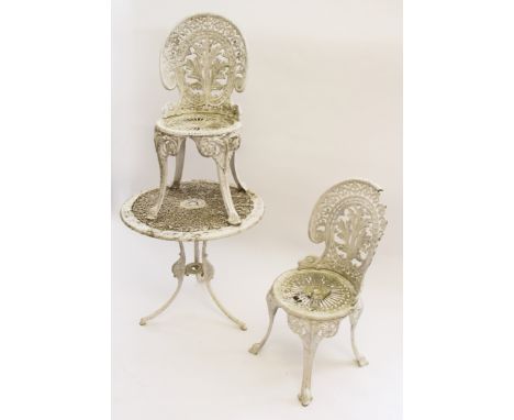 A cast metal white painted garden furniture set including table, chairs and bench.