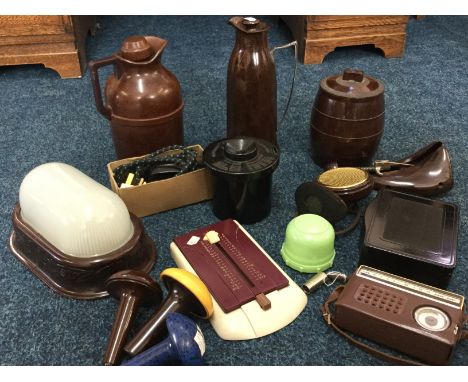 A selection of bakerlite items in various colours including wall light, jugs, Smoothie portable electric iron, Johnsons Hendo