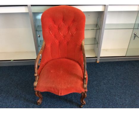 A Victorian 19th Century rosewood armchair with red button back upholstery.