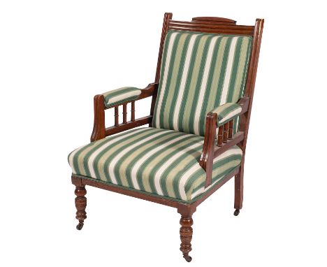 A late Victorian mahogany and upholstered open armchair, circa 1890; channel moulded show frame above padded arm rests and ri