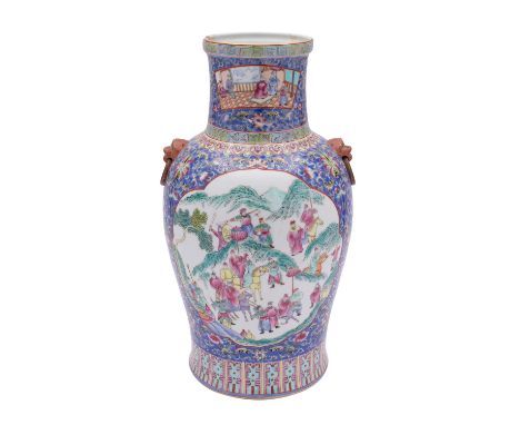 A Chinese famille rose vase with lion dog ring handles, painted with foliate cartouches reserved on a classical floral scroll