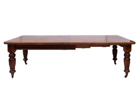 A Victorian walnut extending dining table, last quarter 19th century; the top with moulded edges, canted corners and twin ext