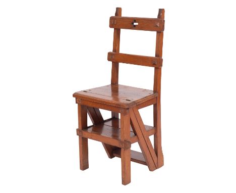 A Victorian oak library step chair, in Gothic taste, last quarter 19th century; the toprail of the backrest with pierced quat