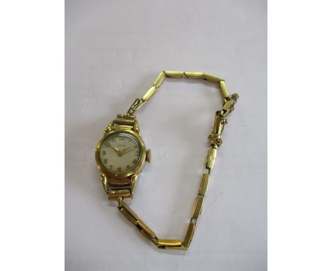 A gold plated ladies watch having an 18ct gold strap 