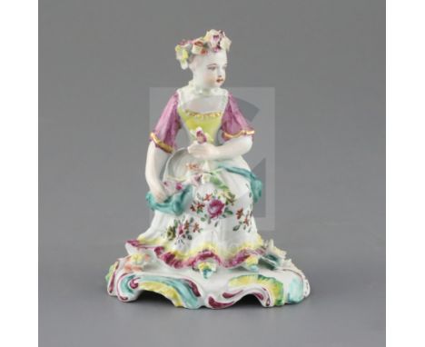 A Derby 'pale family' figure of a seated lady, c.1756-8, holding flowers in her hands on a scrollwork base, patch marks, H. 1