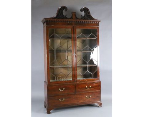 A George III mahogany display cabinet, with blind fret carved swan neck pediment and two astragal glazed doors over two short