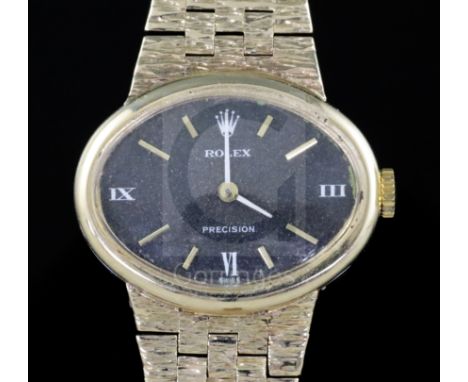 A lady's 1970's 9ct gold Rolex Precision manual wind wrist watch, with black oval dial, on textured 9ct gold bracelet, the cl