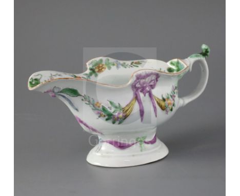 An early Worcester high-footed sauceboat, circa 1752-3, of oval shape, the body embossed with cornucopias of flowers and frui