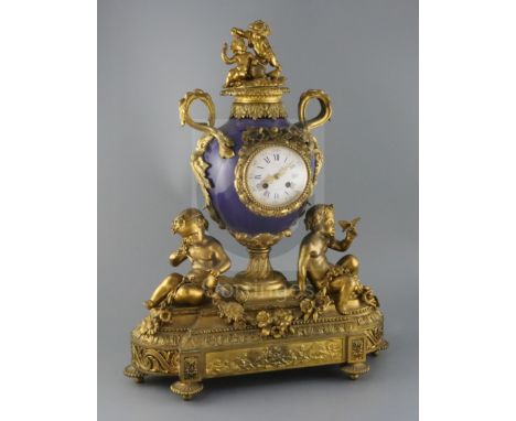 Vernet, Rue du Bac 42. A 19th century French ormolu and bleu du roi porcelain mantel clock, of urn form, flanked by putti hol