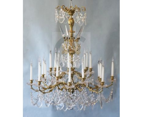 A Louis XV style ormolu and cut glass twenty four light chandelier, with foliate scrolling branches and five tiers of facet c