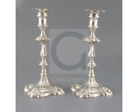 A pair of early George III cast silver candlesticks by Ebenezer Coker, with waisted knopped stems and engraved crest, on deco