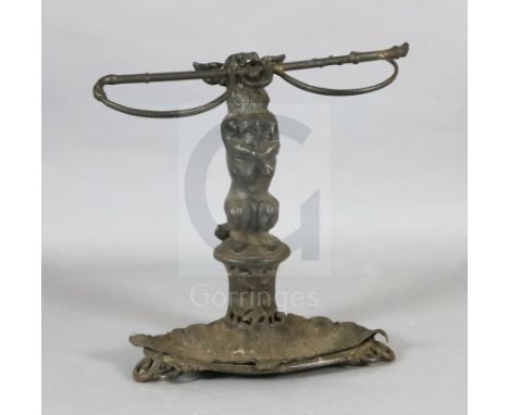 A Victorian cast iron stick stand, modelled as a terrier holding a riding crop, the oval base with foliate dish, stamped with