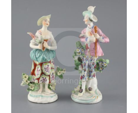 A pair of Derby groups, c.1765, modelled as a man and a woman holding a cockerel, on scrollwork bases, patch marks, H. 17.2 a