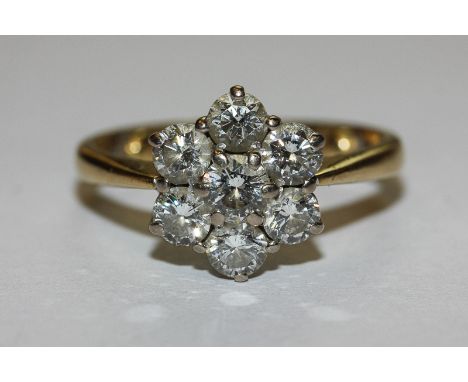 A diamond seven stone cluster ring the graduated round brilliant cuts claw set in 18ct gold