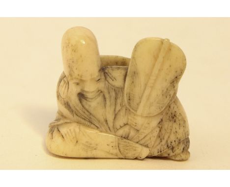 A 19th century carved ivory netsuke of a sage holding a fan, 3cm high