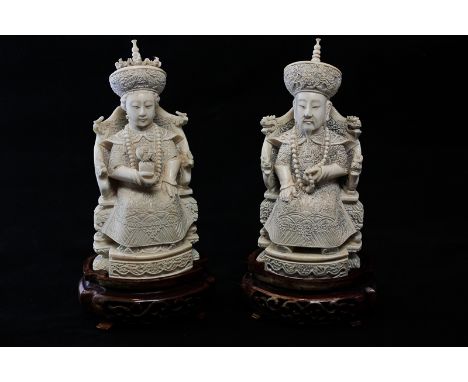 A pair of late 19th, early 20th century Chinese carved ivory figures of mandarin and lady, both with long robes and hats, he 