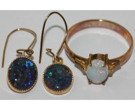 An opal ring four claw set with an oval cut stone in 14ct gold; a pair of opal drop earrings in 14ct gold