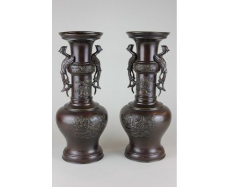 A pair of Japanese bronze vases decorated with dragons and chrysanthemums with phoenix shaped handles, 37cm high