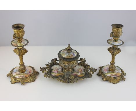 An ornate Victorian gilt metal and enamel plaque decorated inkstand, 12cm high and a pair of matching candlesticks (NC)