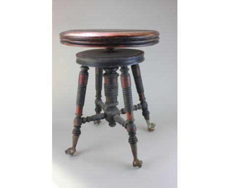A stained wood piano stool with circular adjustable seat on turned legs and brass feet, with glass balls (NC)