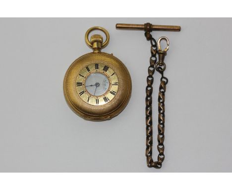 A lady's 18ct gold half hunter fob watch, engine turned on a gilt chain